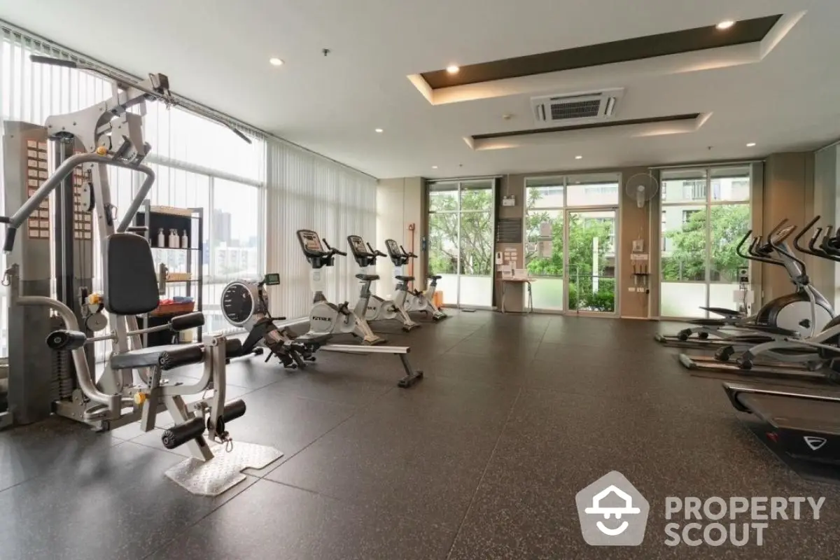 Spacious modern gym with state-of-the-art equipment and city view.