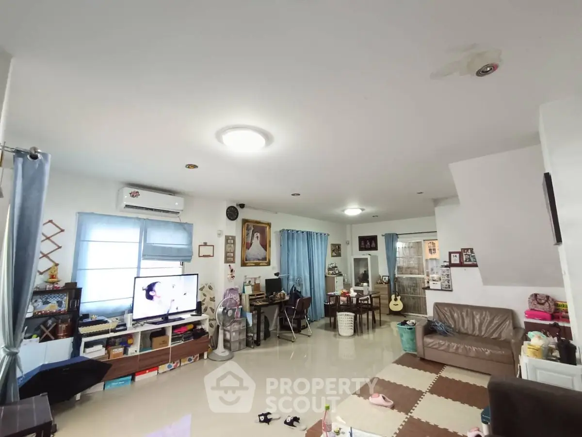 Spacious living room with modern decor and ample natural light, perfect for family gatherings.
