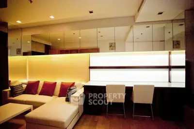 Modern living room with stylish sofa and dining area, featuring elegant lighting and mirrored wall.