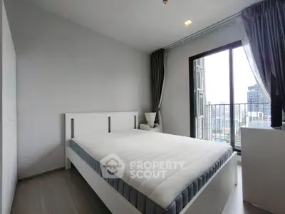 Modern bedroom with city view and large window, featuring a minimalist white bed and sleek design.