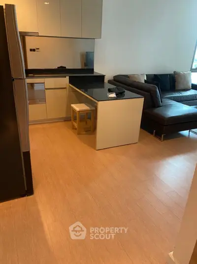 Modern open-layout kitchen and living room with sleek design and cozy seating area.