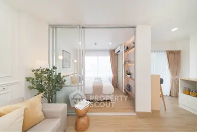 Modern open-plan living room with cozy bedroom, stylish decor, and natural light.