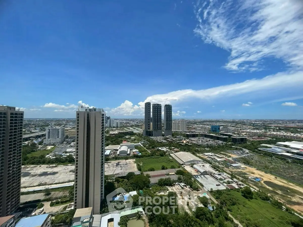 Stunning cityscape view from high-rise building showcasing urban skyline and expansive blue sky.