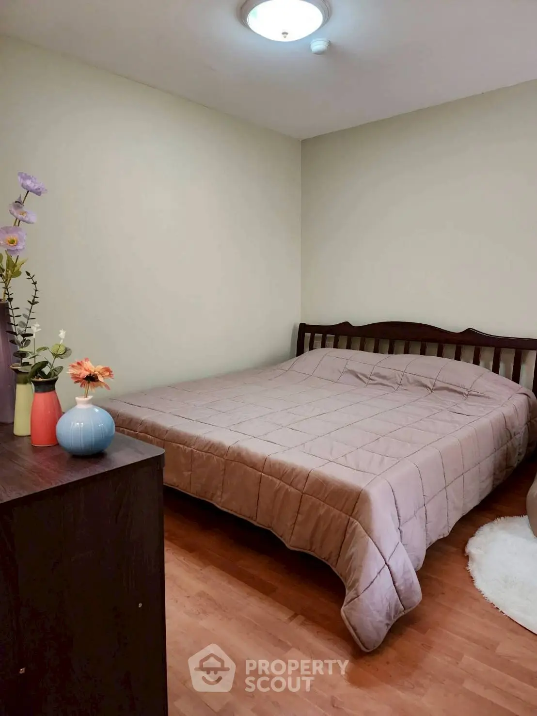 Cozy bedroom with wooden flooring and elegant decor, perfect for relaxation.