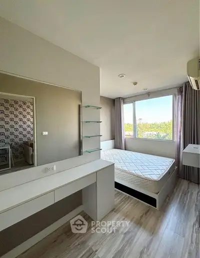 Modern bedroom with large window and stylish decor in a bright apartment.