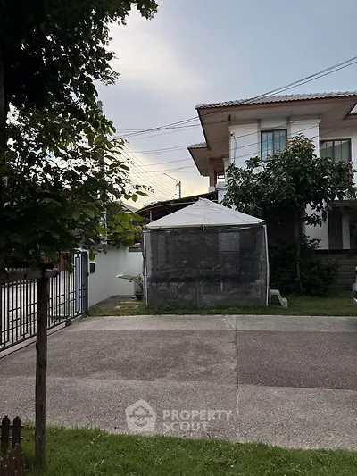 Charming suburban house with spacious driveway and lush greenery, perfect for family living.