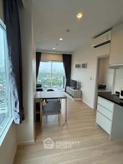 Modern living room with city view, featuring sleek furniture and large windows for natural light.