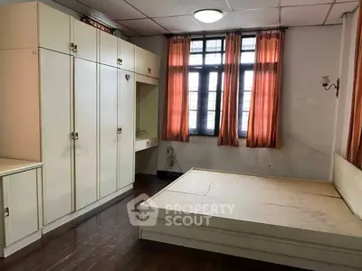 Spacious bedroom with built-in wardrobe and large windows