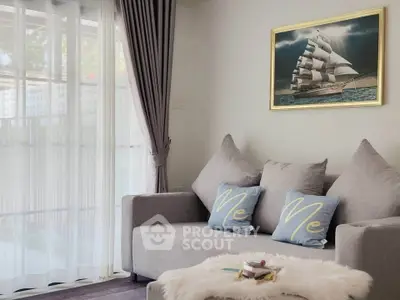 Cozy living room with modern gray sofa and nautical artwork, perfect for relaxation.