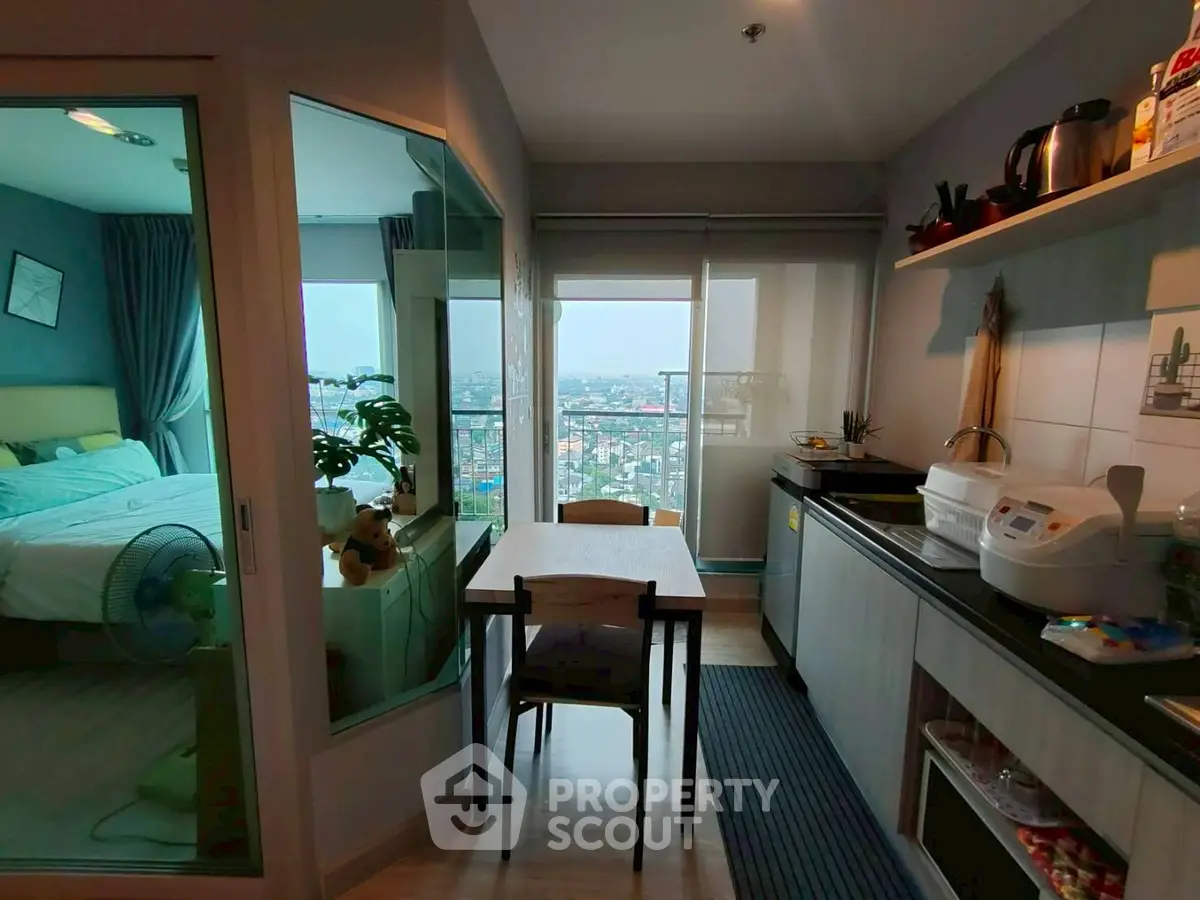 Modern apartment with city view, cozy kitchen, and adjacent bedroom.