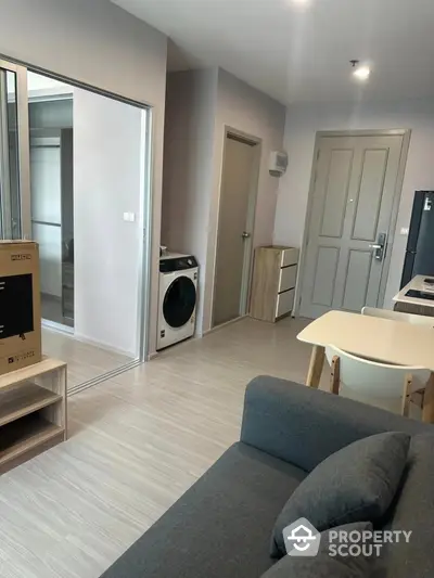 Modern apartment living room with stylish furniture and in-unit washing machine