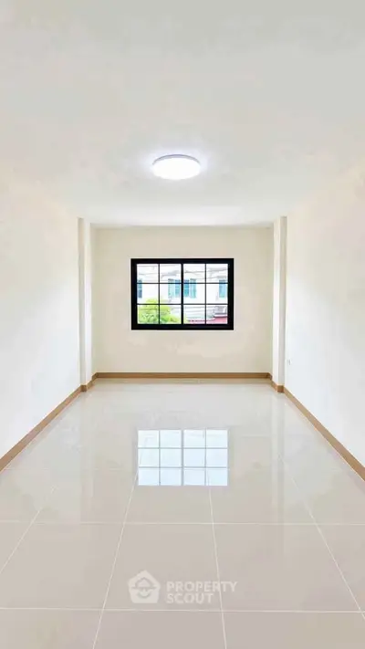 Spacious empty room with large window and glossy tiled floor, perfect for customization.