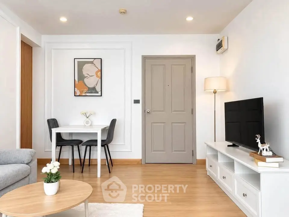 Modern living room with stylish decor, featuring a cozy seating area, flat-screen TV, and elegant dining space.