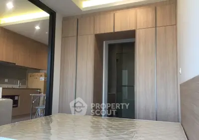 Modern bedroom with built-in wooden wardrobe and open kitchen layout