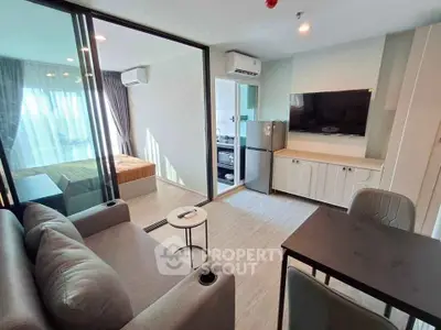 Modern apartment interior with open living room and kitchen, featuring sleek furniture and natural light.