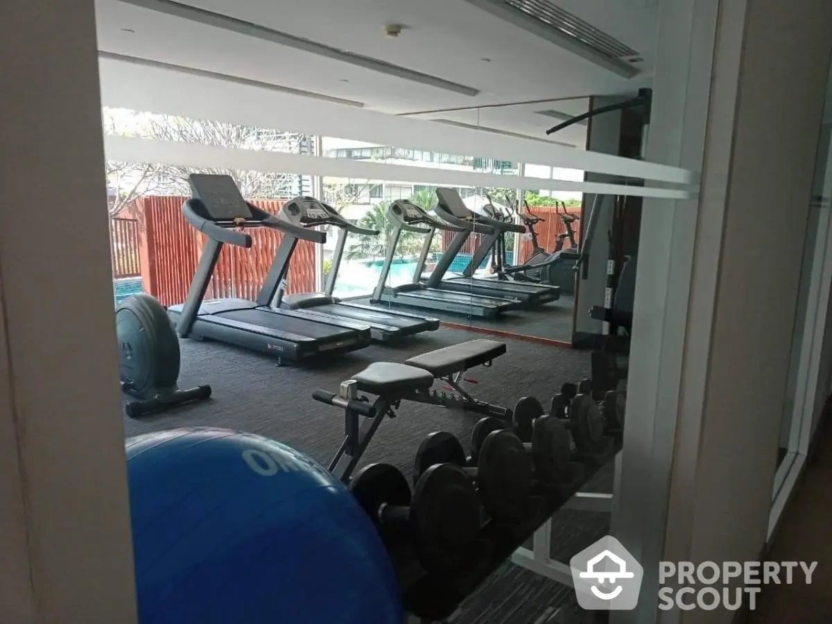 Modern gym with treadmills and weights in luxury apartment complex