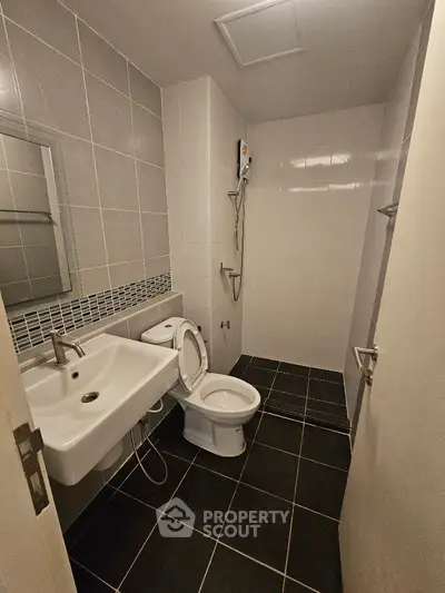 Modern bathroom with sleek design and tiled walls in a contemporary apartment.