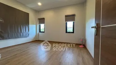 Spacious empty room with wooden flooring and natural light, ideal for customization.