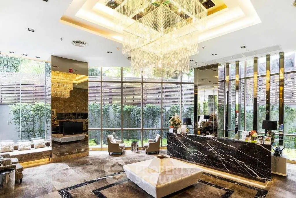 Luxurious modern lobby with elegant chandelier and marble accents in upscale building.