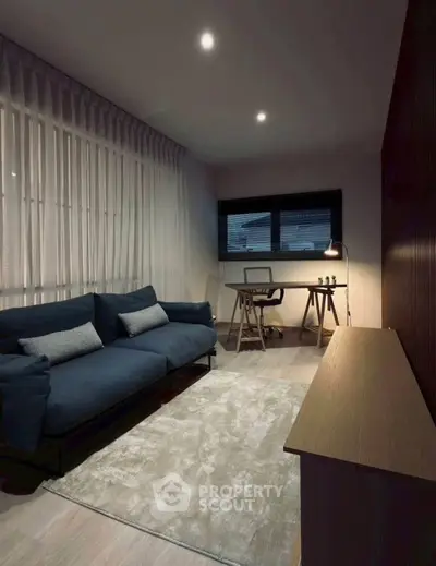 Modern living room with stylish sofa and study desk, perfect for relaxation and work.