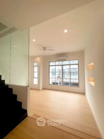 Spacious living room with large windows and modern design in a bright apartment.