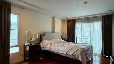 Spacious bedroom with elegant decor and large windows for natural light