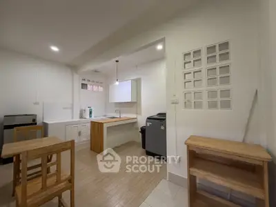 Modern kitchen with open layout and wooden furniture, featuring a compact design and efficient use of space.