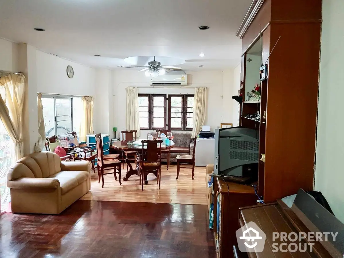 Spacious living room with polished hardwood floors, ample natural light, and comfortable seating, ideal for family gatherings and entertaining guests.