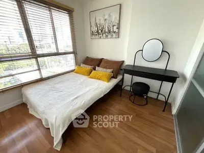 Cozy bedroom with city view, featuring a stylish vanity and modern decor.