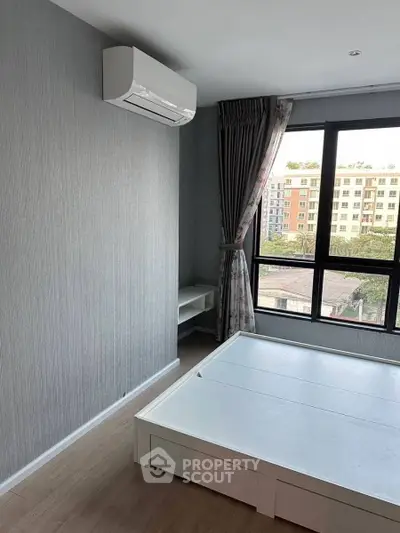 Modern bedroom with large window and air conditioning, offering a bright and comfortable living space.