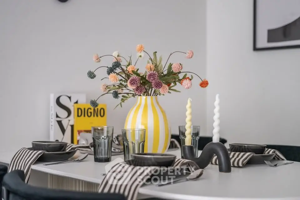 Stylish dining table setup with modern decor and vibrant floral centerpiece.