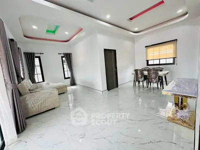 Spacious modern living room with elegant dining area and stylish ceiling design.