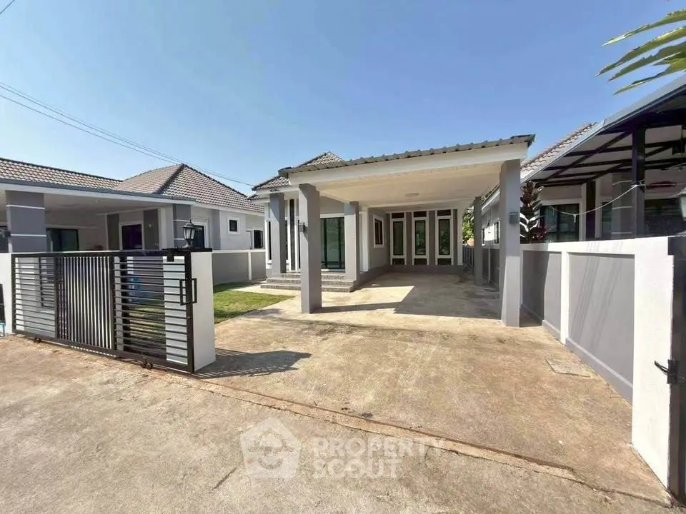 Modern single-story house with spacious driveway and contemporary design.