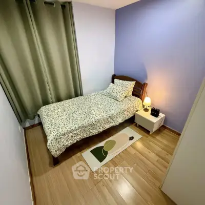 Cozy bedroom with single bed, wooden flooring, and soft lighting, perfect for relaxation.