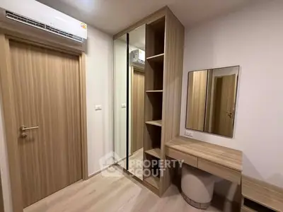 Modern bedroom with mirrored wardrobe and stylish vanity in a cozy apartment.