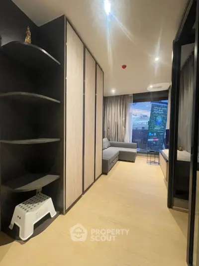 Modern living room with sleek design and city view from large window.