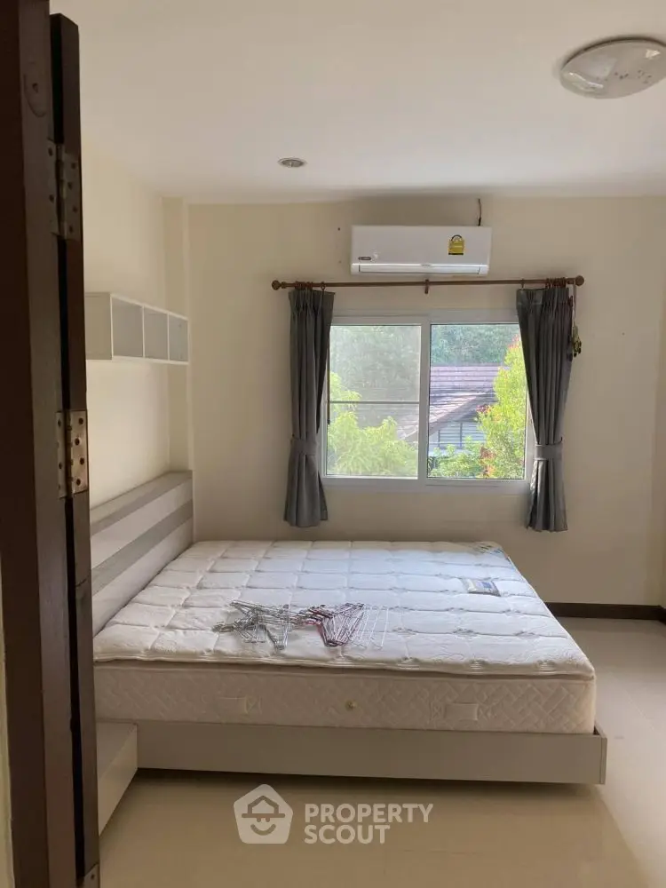 Cozy bedroom with large window and air conditioning unit