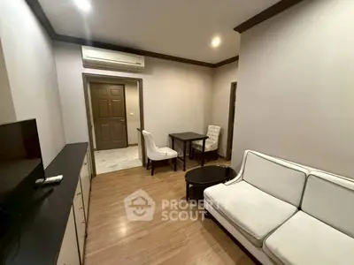 Cozy living room with modern furniture and wooden flooring, perfect for relaxation.