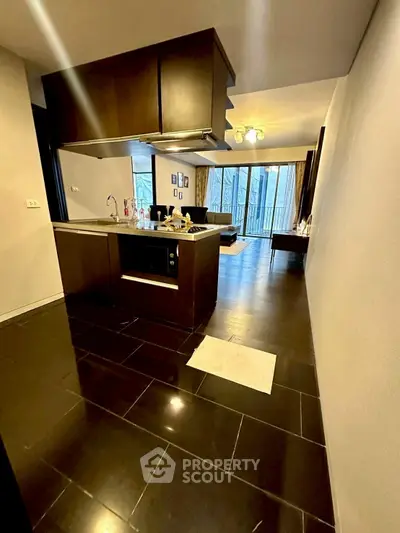 Modern open-layout kitchen with sleek dark flooring and stylish lighting