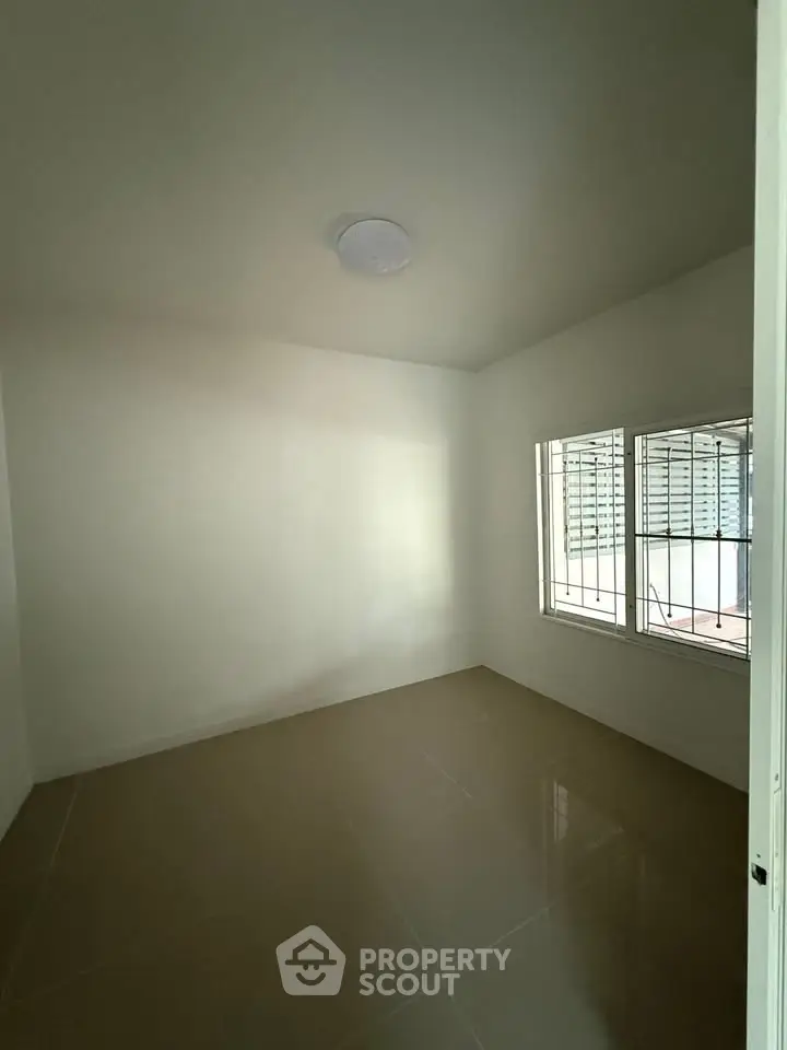 Minimalist empty room with tiled floor and window, ideal for customization.