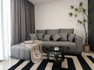 Stylish modern living room with gray sofa, chic black coffee table, and elegant decor.