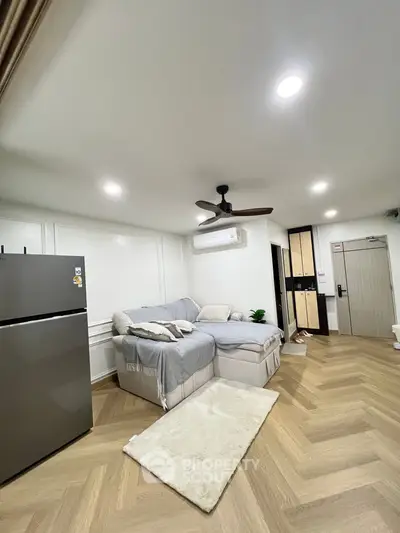 Modern living room with cozy sectional sofa and sleek refrigerator