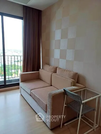 Cozy living room with a sofa and balcony view in modern apartment