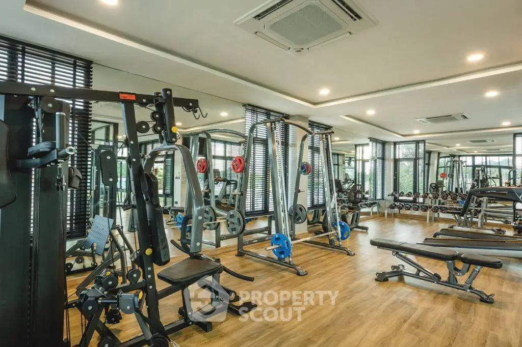 Spacious modern gym with state-of-the-art fitness equipment and mirrored walls.