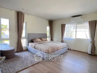 Spacious and bright bedroom with modern decor and large windows