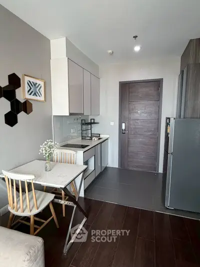 Modern kitchen with sleek cabinetry and dining area in stylish apartment
