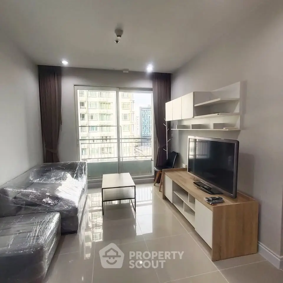 Modern living room with sleek furniture and large windows in a high-rise apartment.