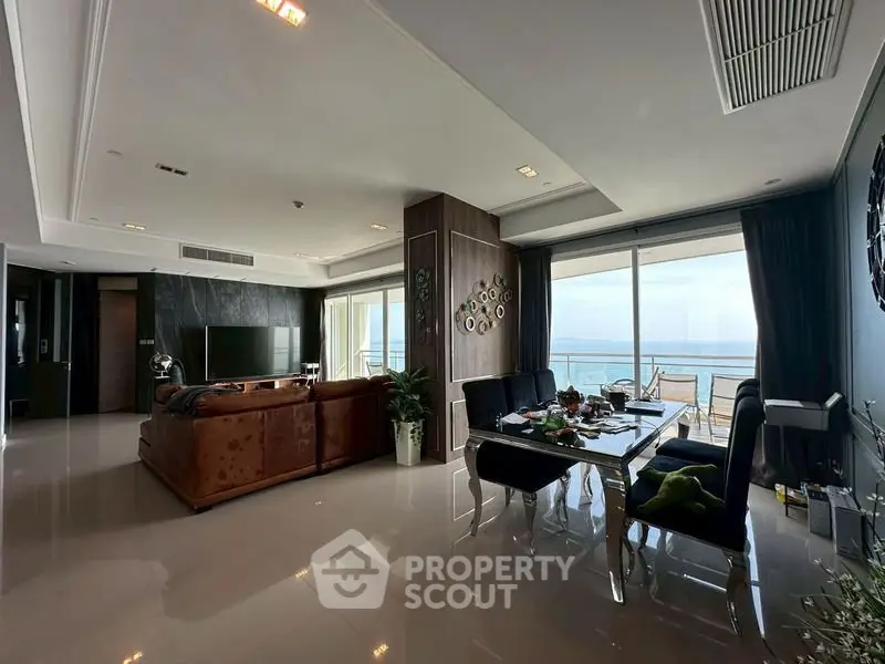 Luxurious living room with ocean view and elegant dining area in modern apartment.