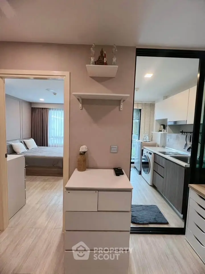 Modern apartment interior with open kitchen and cozy bedroom view.