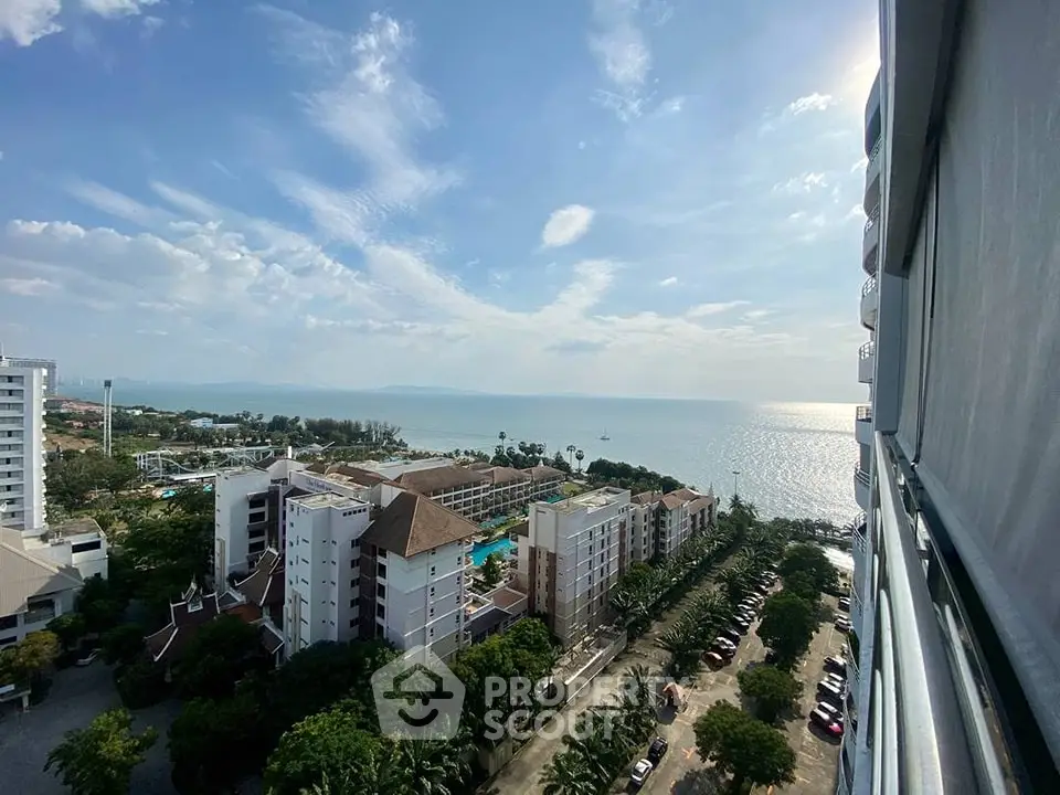 Stunning ocean view from high-rise building balcony overlooking lush greenery and coastline.